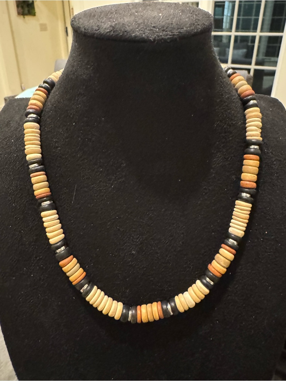 Boho tribal-style necklace featuring natural wood disc beads in black, tan and o